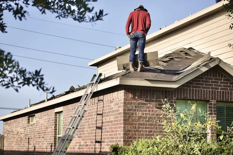 Professional roofer working on a residential roof in Office Hall